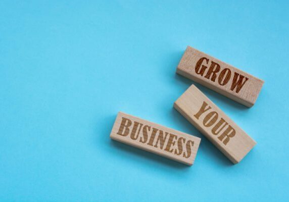 blocks arranged haphazzardly on a blue background with the words Grow Your Business