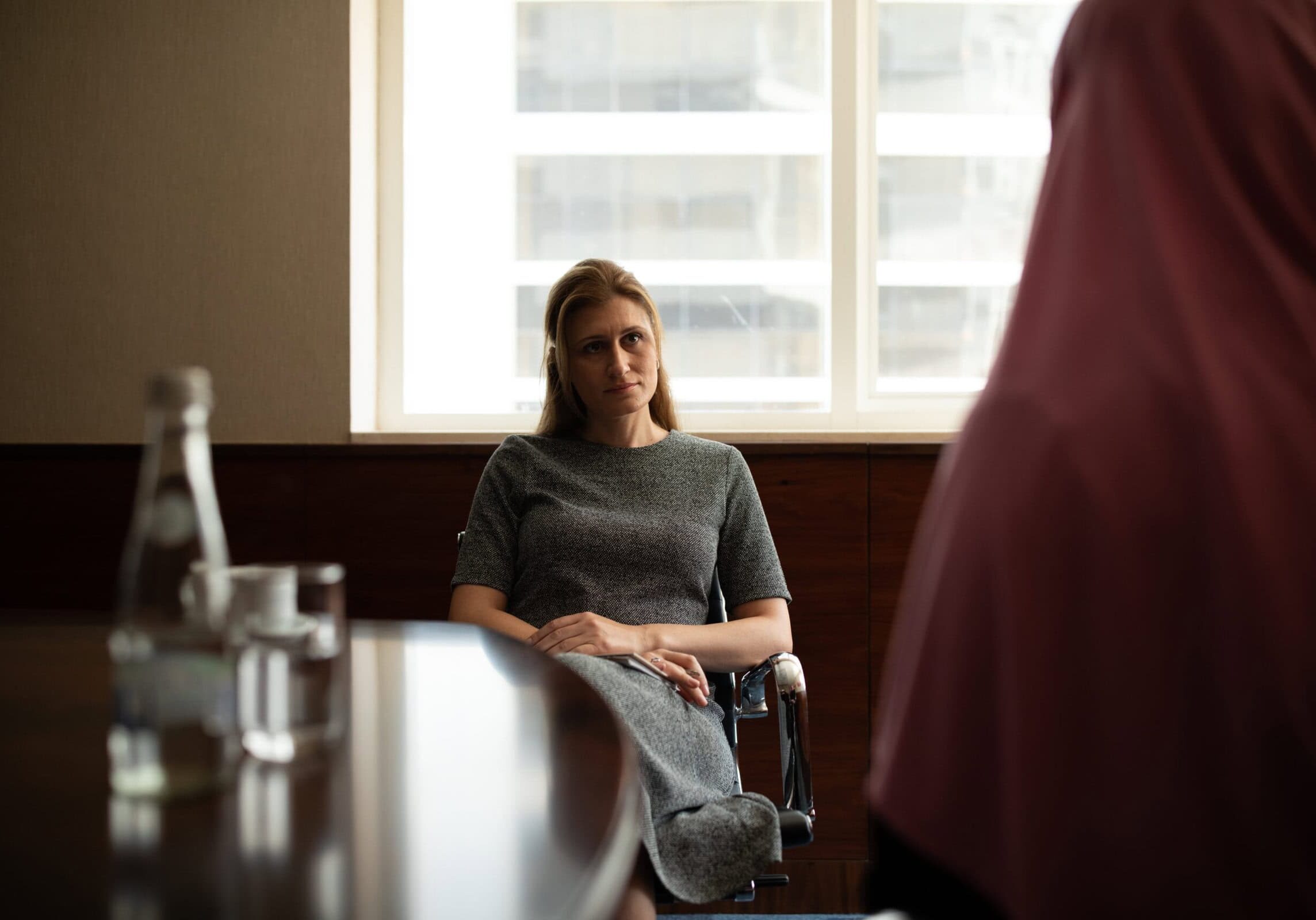 Professional woman coach attentively listening during a coaching session, reflecting professionalism and focused coaching techniques.