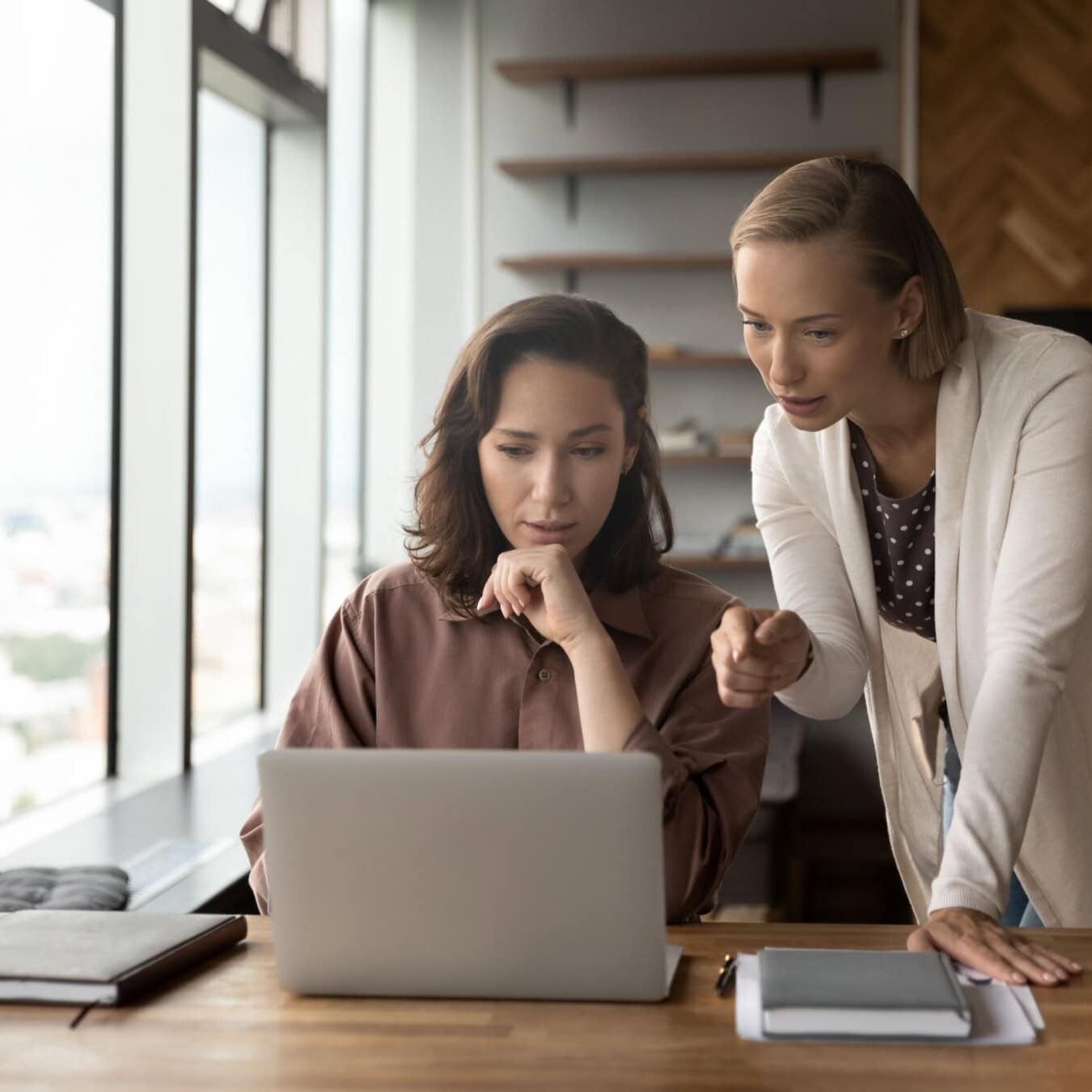 Two women look at a computer and view the ICF Credential Application paths