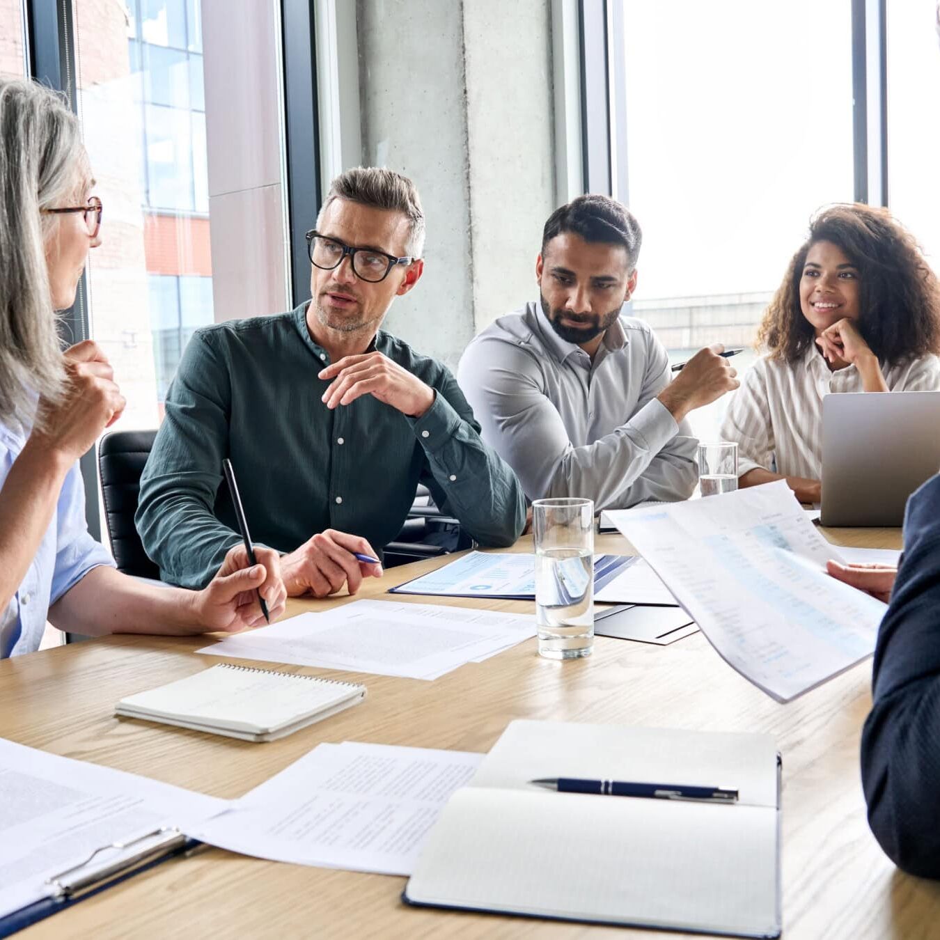 A group of people work together in an office setting at a table