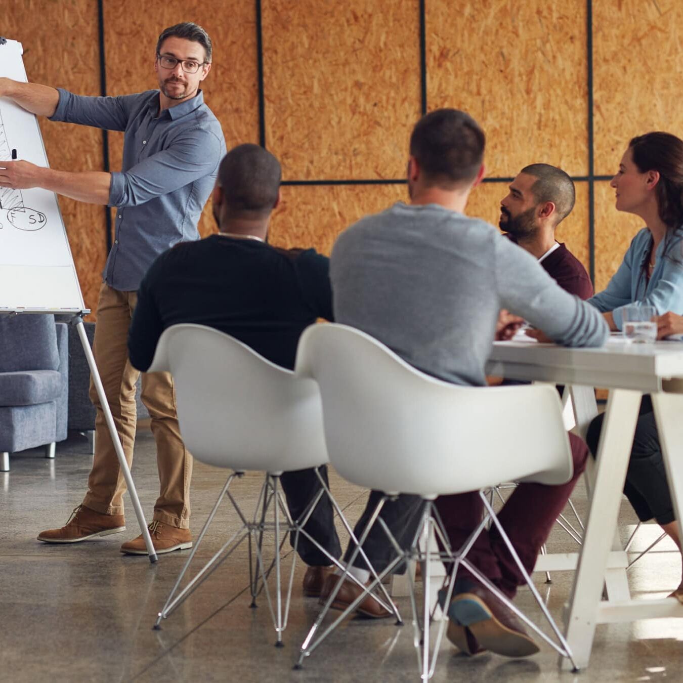A man presents to a group of people in an organizations about coaching cultures