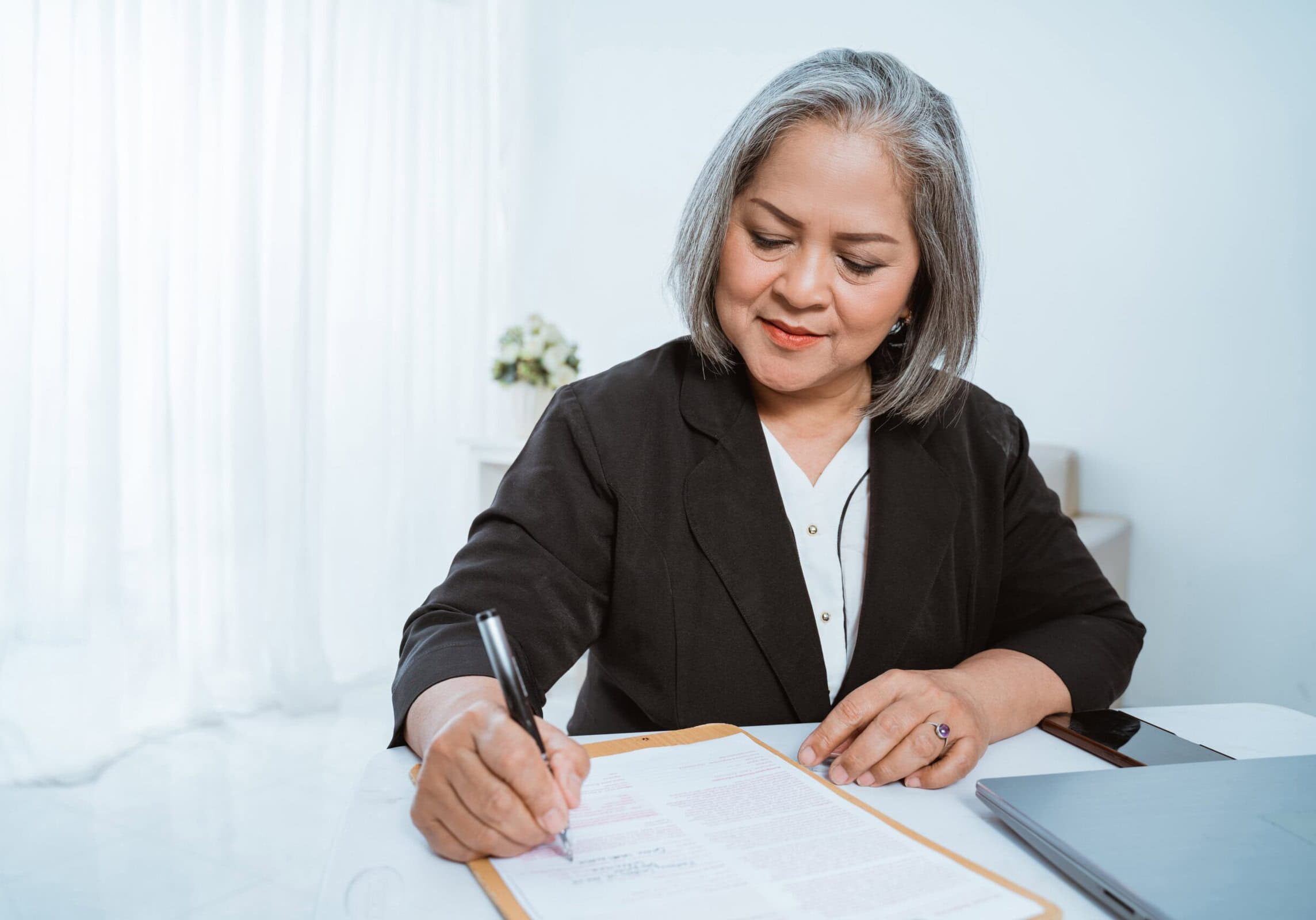A guide to the ICF Competency Framework open on a tablet, with a pen and notebook nearby.