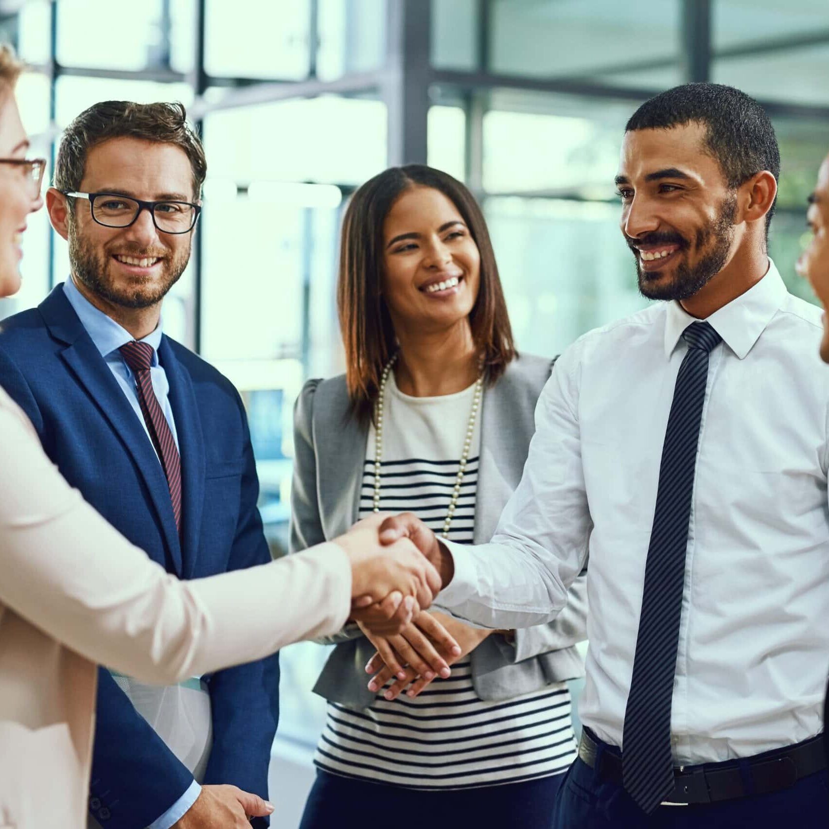 people standing in a circle shaking hands in meeting