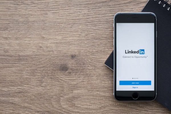 cellphone on wood table with LinkedIn app open